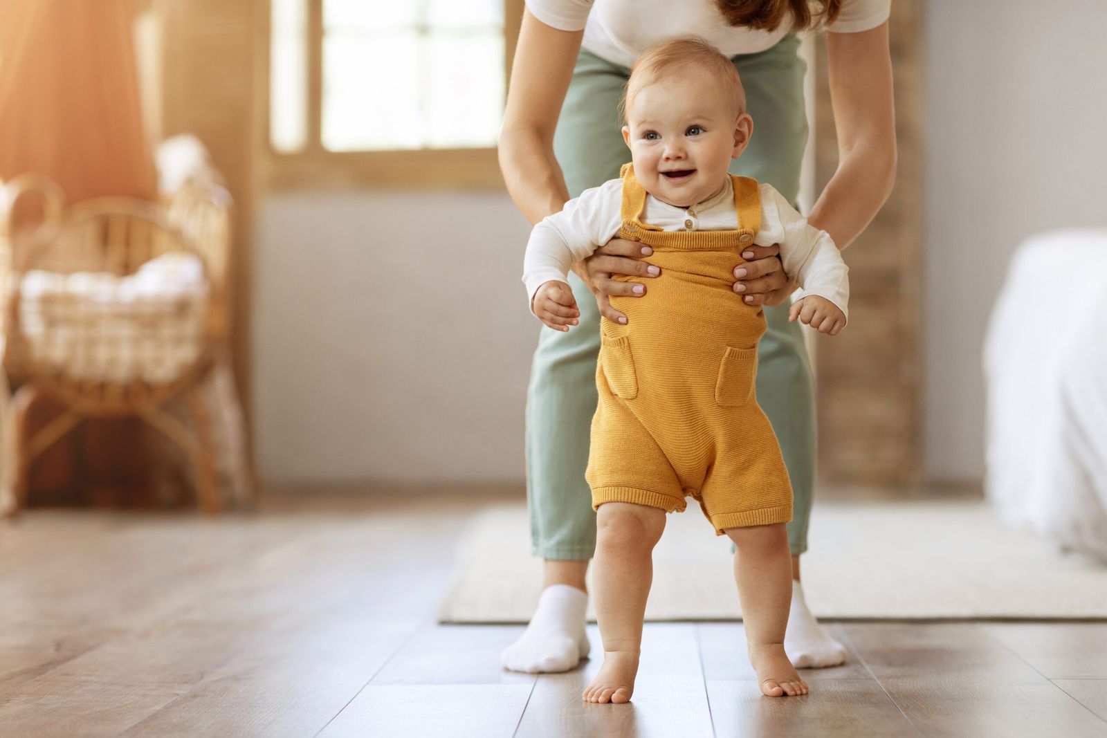 Baby taking their first steps with their mother's help